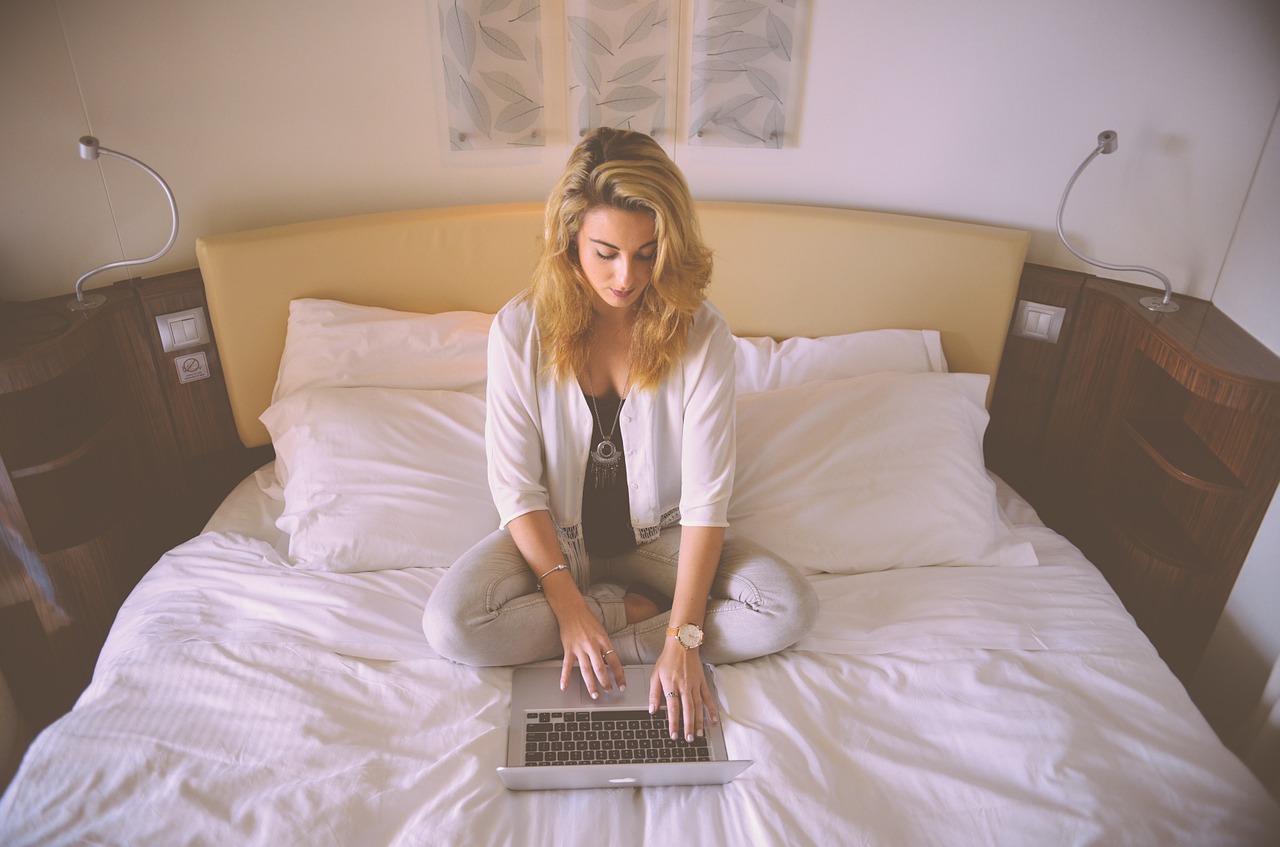 A girl on the computer in bed.